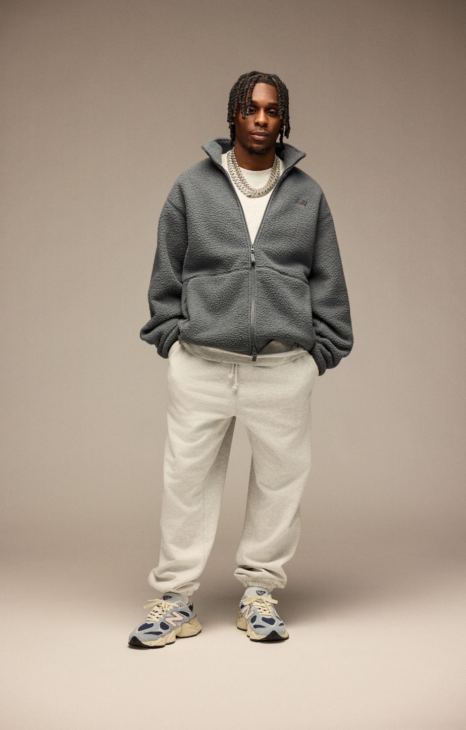 Jeremie Frimpong wearing New Balance Sneakers on a beige background. 